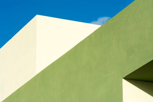 Free Abstract view of green and white geometric architecture with a clear blue sky backdrop. Stock Photo