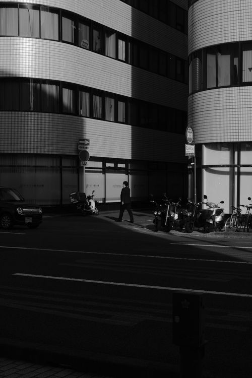 Free Black and white street scene featuring urban architecture and a pedestrian crossing. Stock Photo