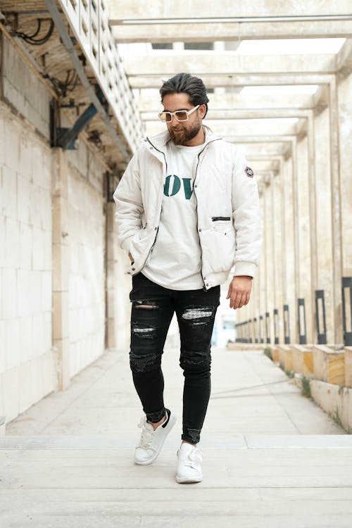 Free Man in White Zip Up Jacket and Blue Denim Jeans Standing on Sidewalk Stock Photo