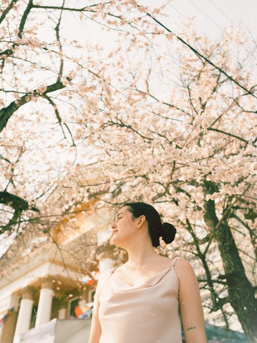 Woman in Beige Dress Standing Near Flowering Trees