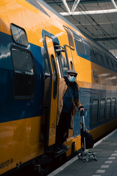 A Man Wearing Face Mask while Standing on the Train