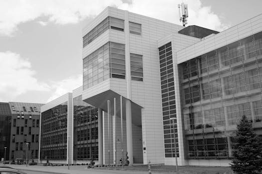 Black and white photo of a modern office facade in Osijek, Croatia with glass and geometric design.