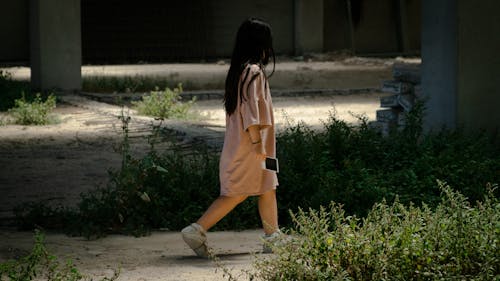 Child Walking with a Photograph in Her Hand 