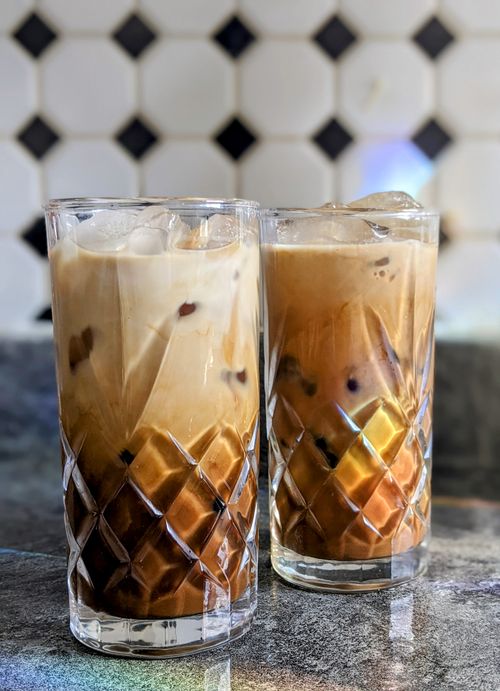 Free Close-up of two iced coffees in elegant crystal glasses on a marble surface, perfect for summer. Stock Photo