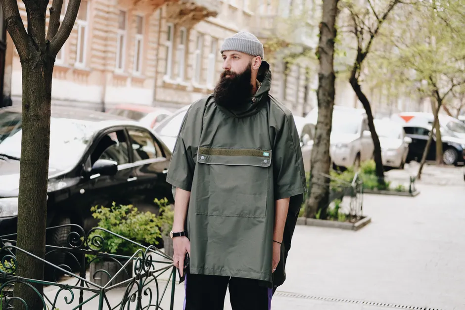 Homme en bonnet tricoté gris et surchemise kaki dans une rue parisienne