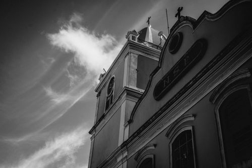 Free Low-angle black and white photo of a historic church against a cloudy sky. Stock Photo