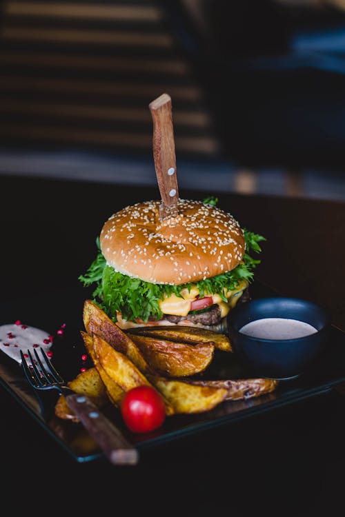 Free Burger With Fried Fries on Black Plate With Sauce on the side Stock Photo