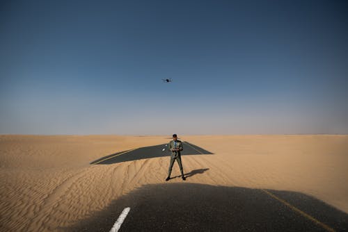 Free Man Standing in the Middle of Desert Place Stock Photo