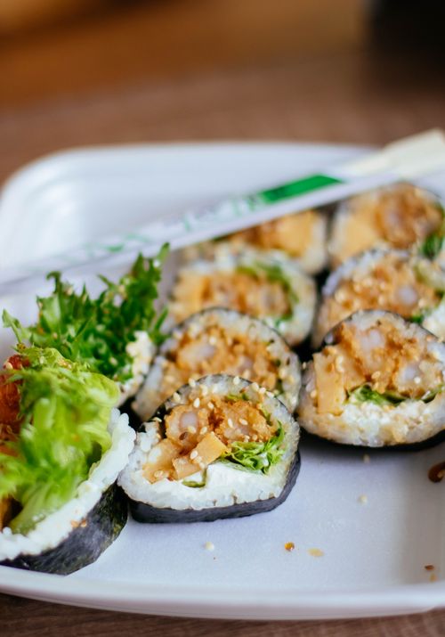 Free Close-up of fresh sushi rolls with vegetables on a white plate, perfect for a healthy meal. Stock Photo