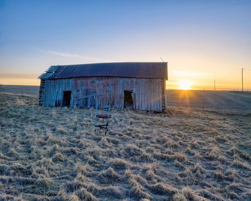 Free Rustic abandoned barn on a rural Minnesota farmland at sunrise, showcasing natural beauty. Stock Photo