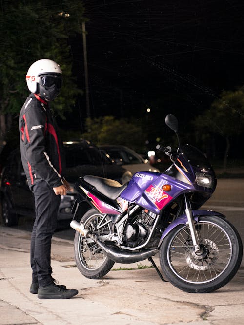 Bike Rider standing beside a Motorbike 