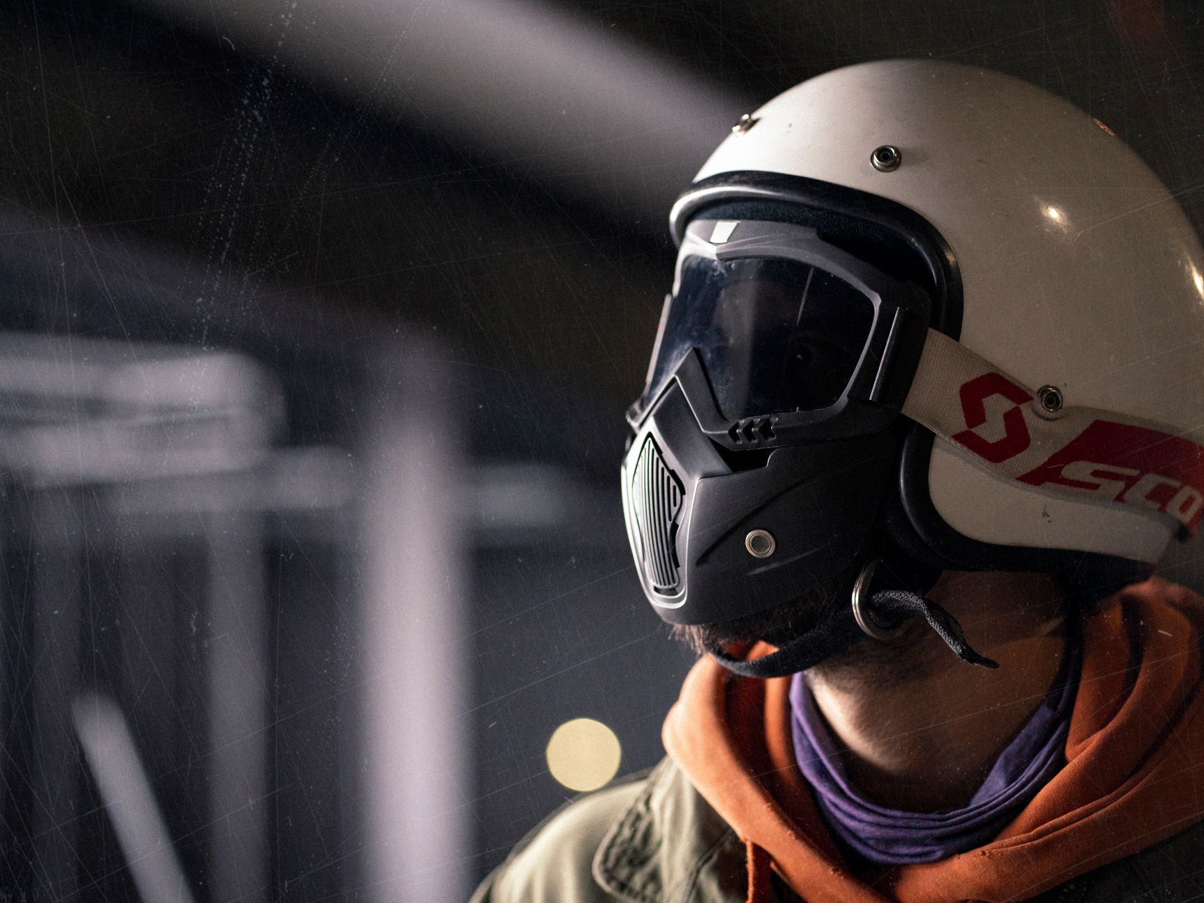 Close-up of a man wearing a stylish motorcycle helmet indoors, highlighting modern style and safety.