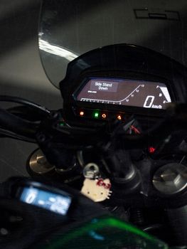 Detailed view of a sports bike dashboard with illuminated display showing 'Side Stand Down'.