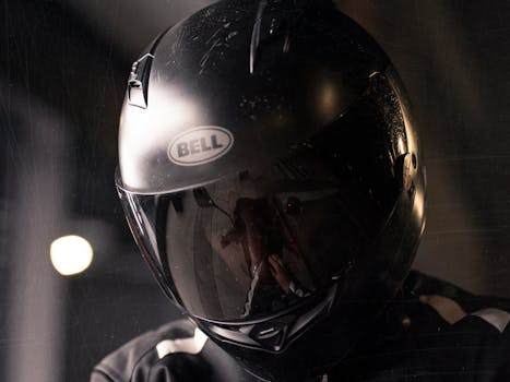 Reflective shot of a motorcyclist wearing a black helmet highlighting safety.