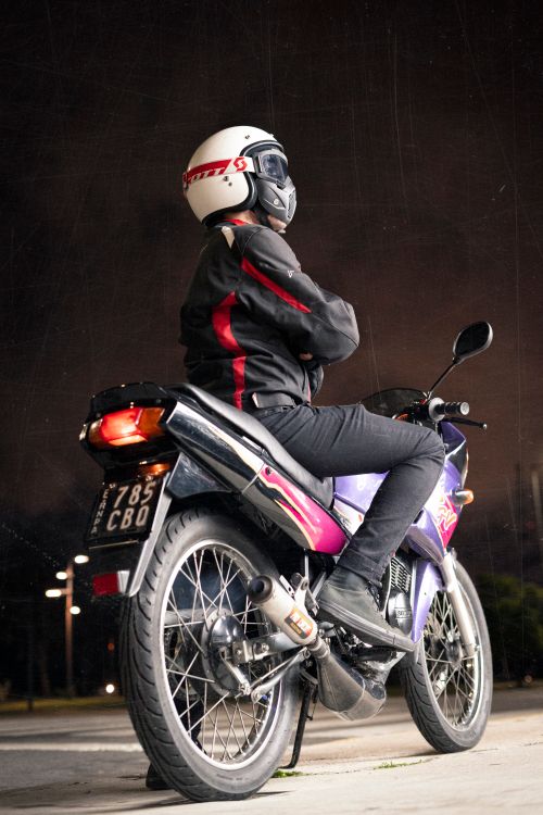 Free A motorcyclist wearing safety gear rides a Suzuki sports bike under the night sky. Stock Photo