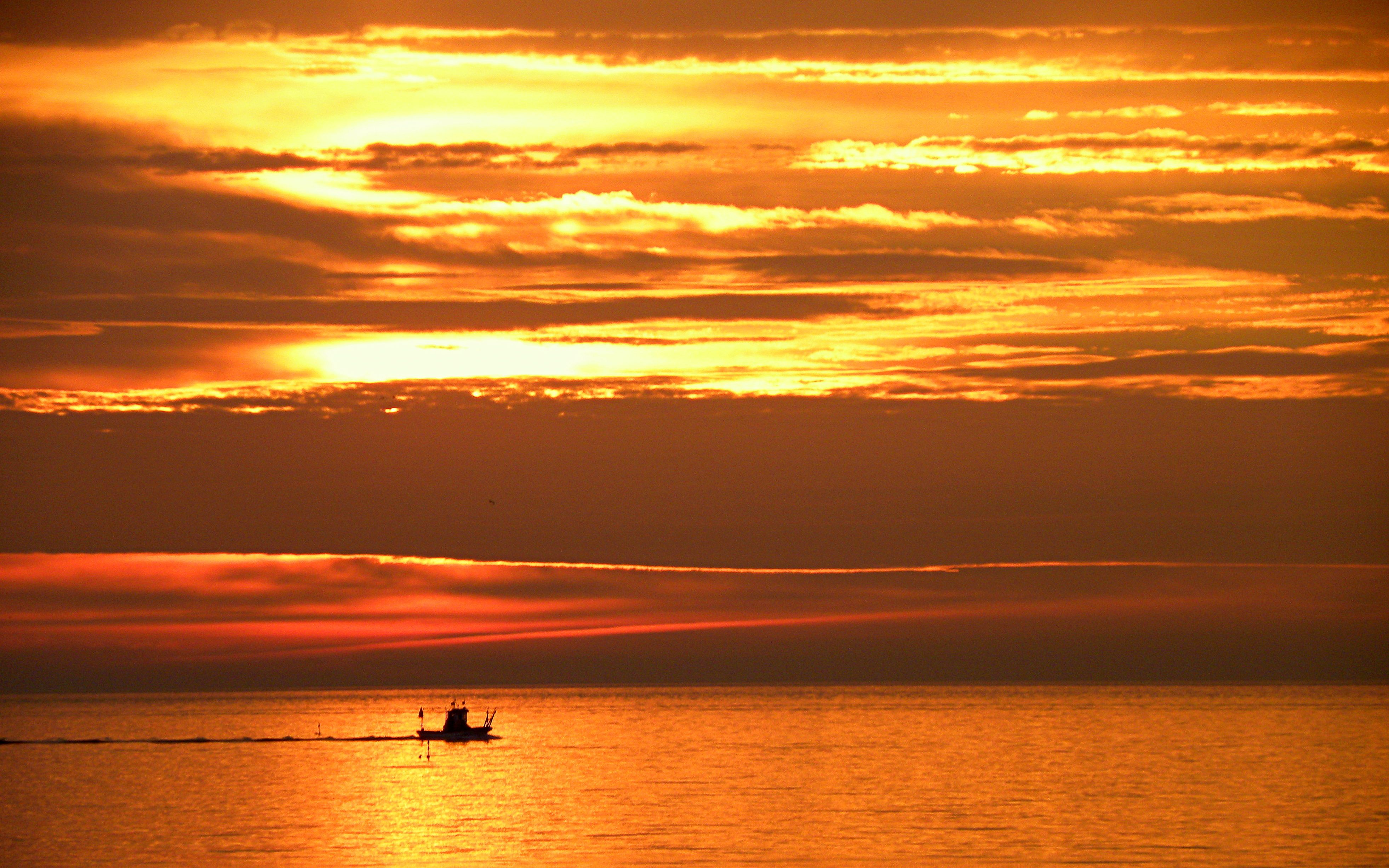 Silhouette of a Boat on Water at Sunset · Free Stock Photo