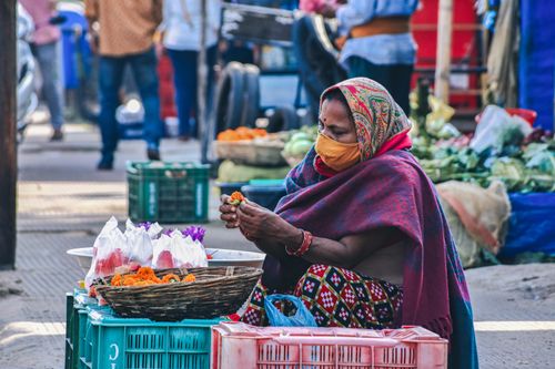 Free A woman wearing a face mask sells flowers at a street market in Bhubaneswar, India. Stock Photo