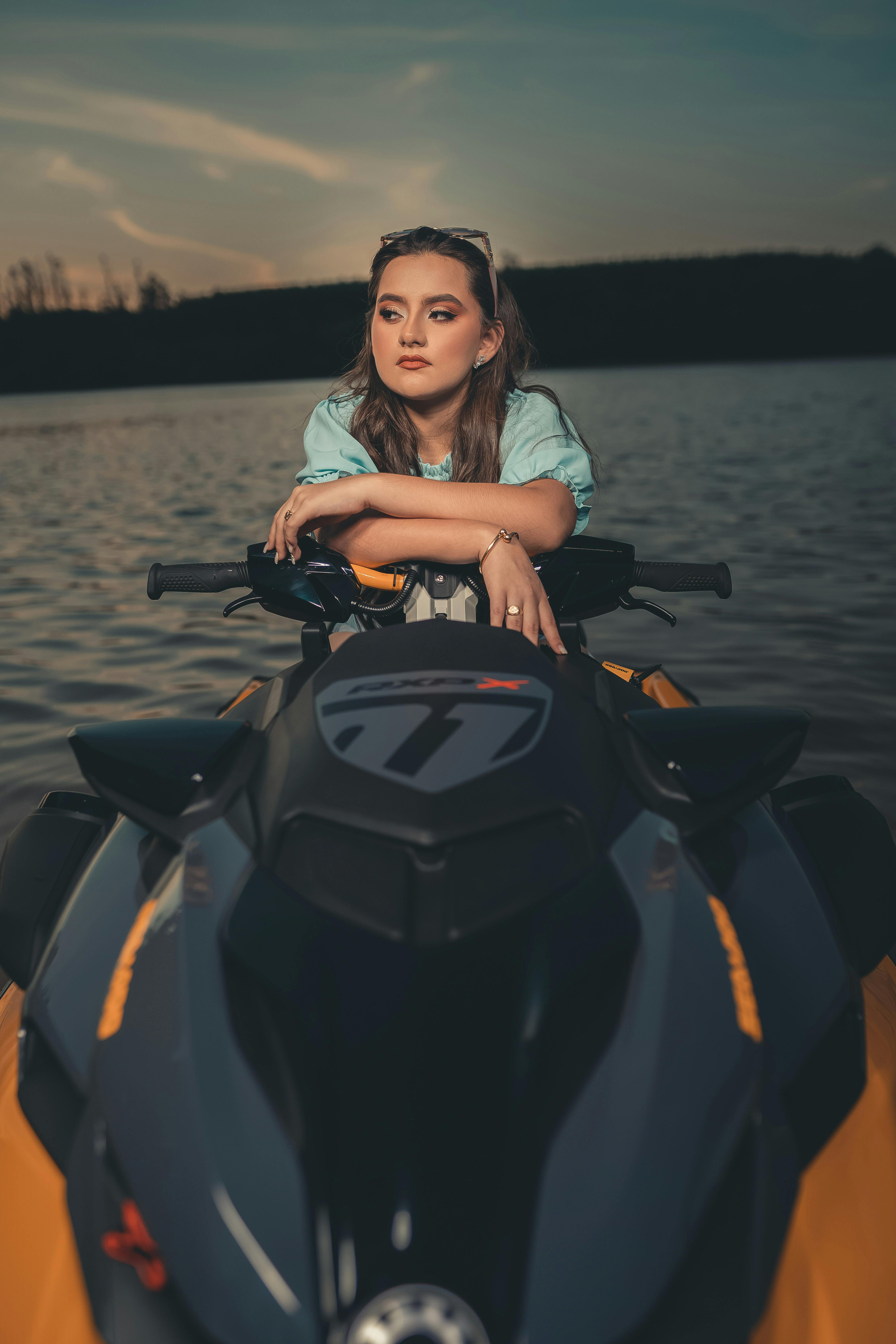 a woman in blue blouse riding a jet ski