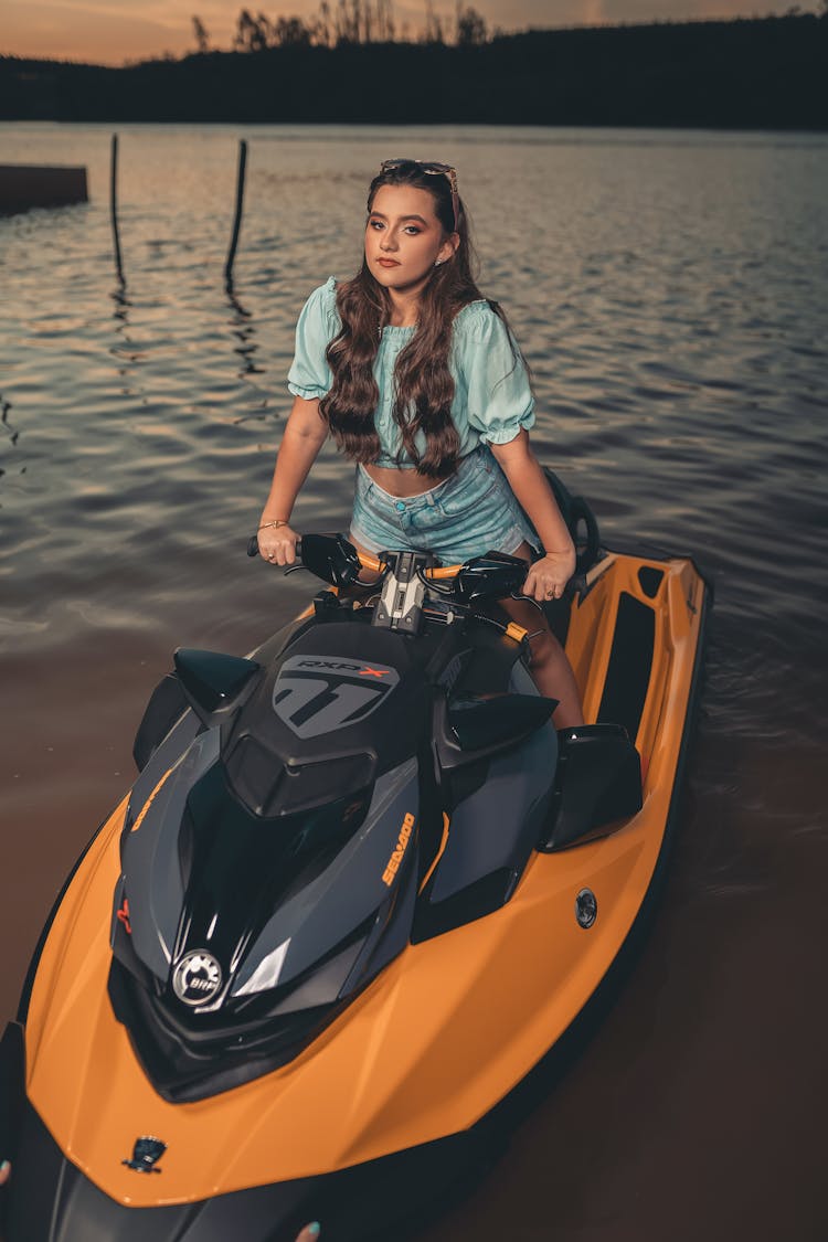 A Woman In Denim Shorts Riding A Jetski