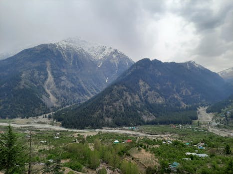 A scenic aerial view of snow-capped mountains with a cloudy sky, showcasing nature's beauty.