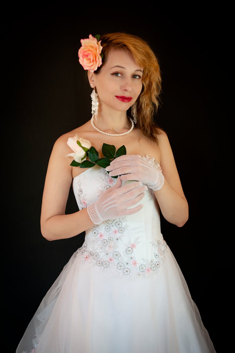 A Woman In White Tube Wedding Dress Holding A White Rose