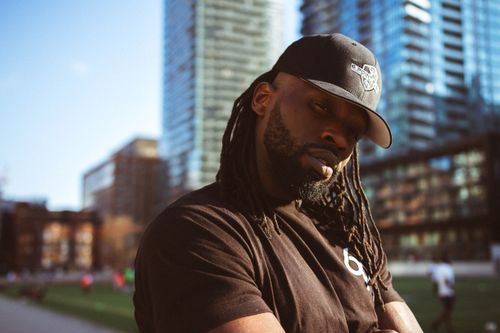 Free Confident man with dreadlocks in black cap outdoors in urban environment. Stock Photo