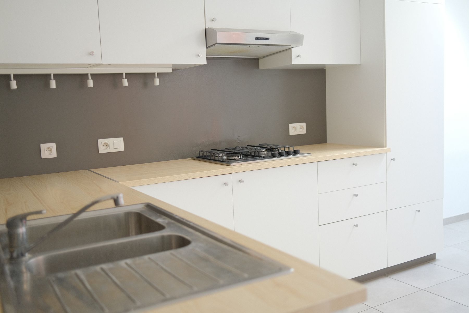 Compact kitchen counter with sink and hob on the same run beneath cabinetry