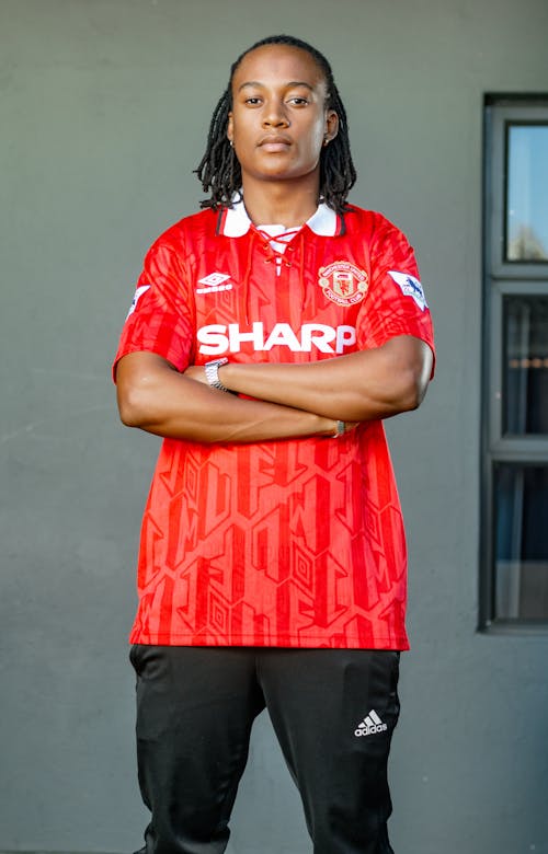 A Man in Red Shirt Standing with His Arms Crossed