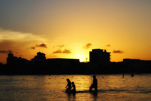 Free Silhouettes of a family enjoying a mesmerizing sunset at Cancún beach. Stock Photo