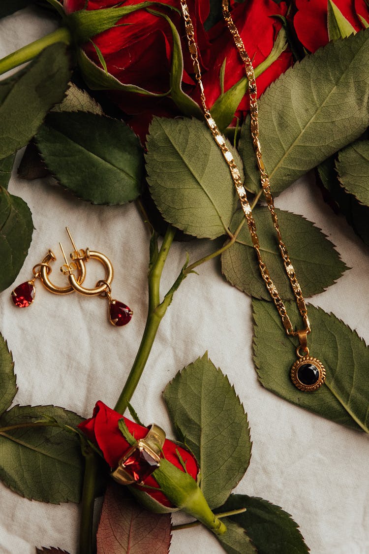 Top View Of Golden Jewellery On Roses