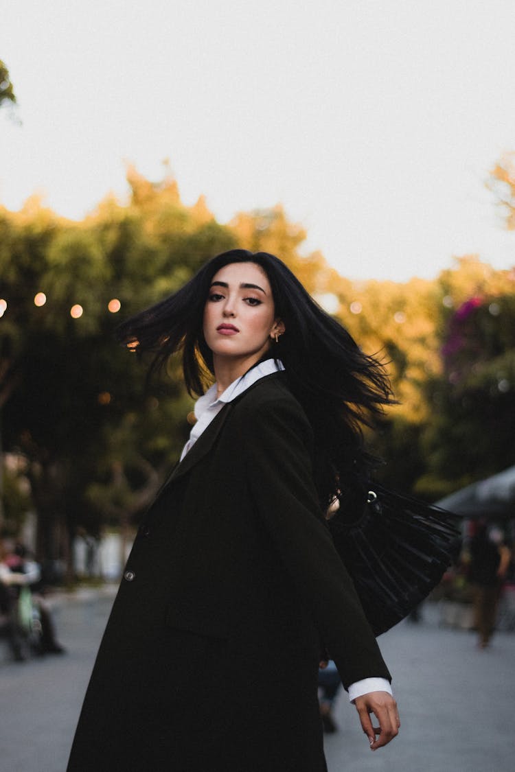 Attractive Woman In Black Coat Turning Back