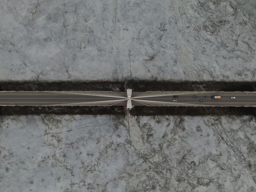 Drone shot of cable-stayed Murom Bridge over frozen Oka River in Russia.