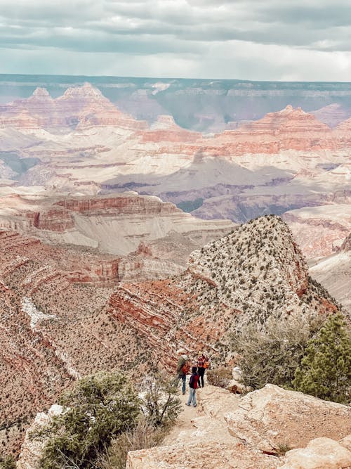 Free People Standing on Brown Rock Formation Stock Photo