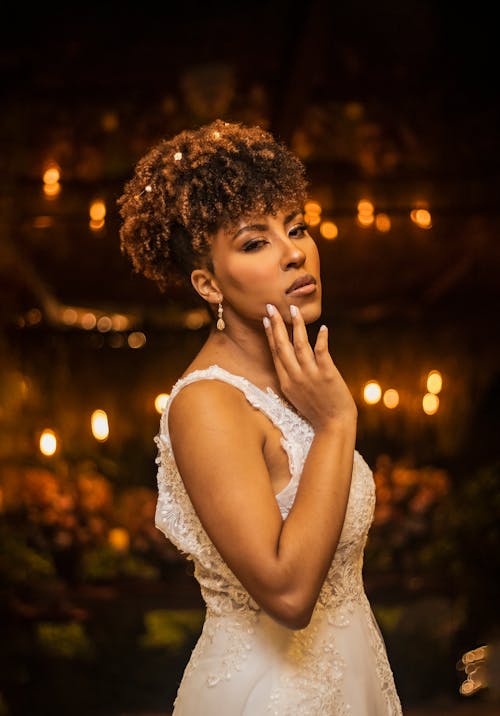 Bride Standing on the Background of Warm Lights in the Evening 