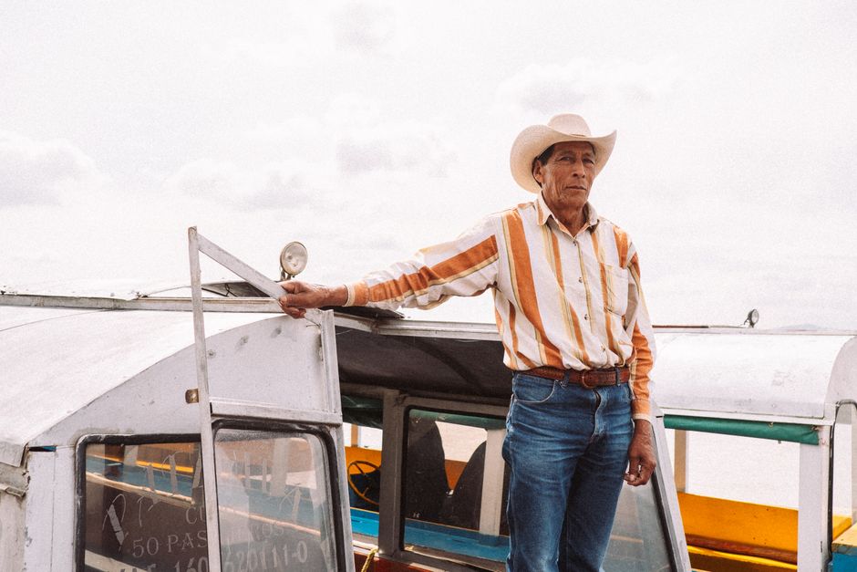 A man in a cowboy hat and striped shirt standing on a boat at Isla de Pacanda, Mexico.