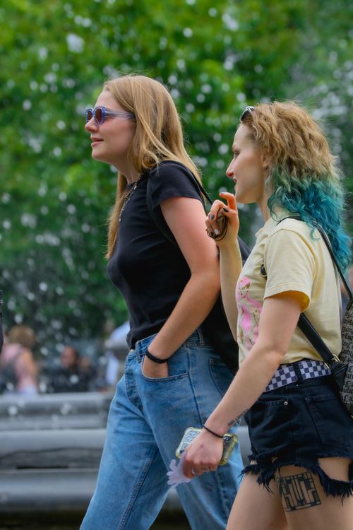 Free Two young women walking outdoors in a New York City park during summer. Stock Photo