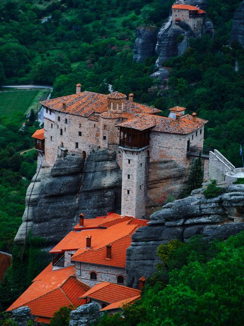 Free Stunning aerial photograph of a historic monastery perched on a rocky hill surrounded by lush greenery. Stock Photo