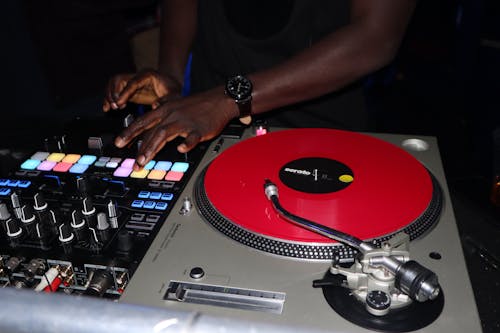 Free A Person Using an Audio Mixer and Turntable Stock Photo