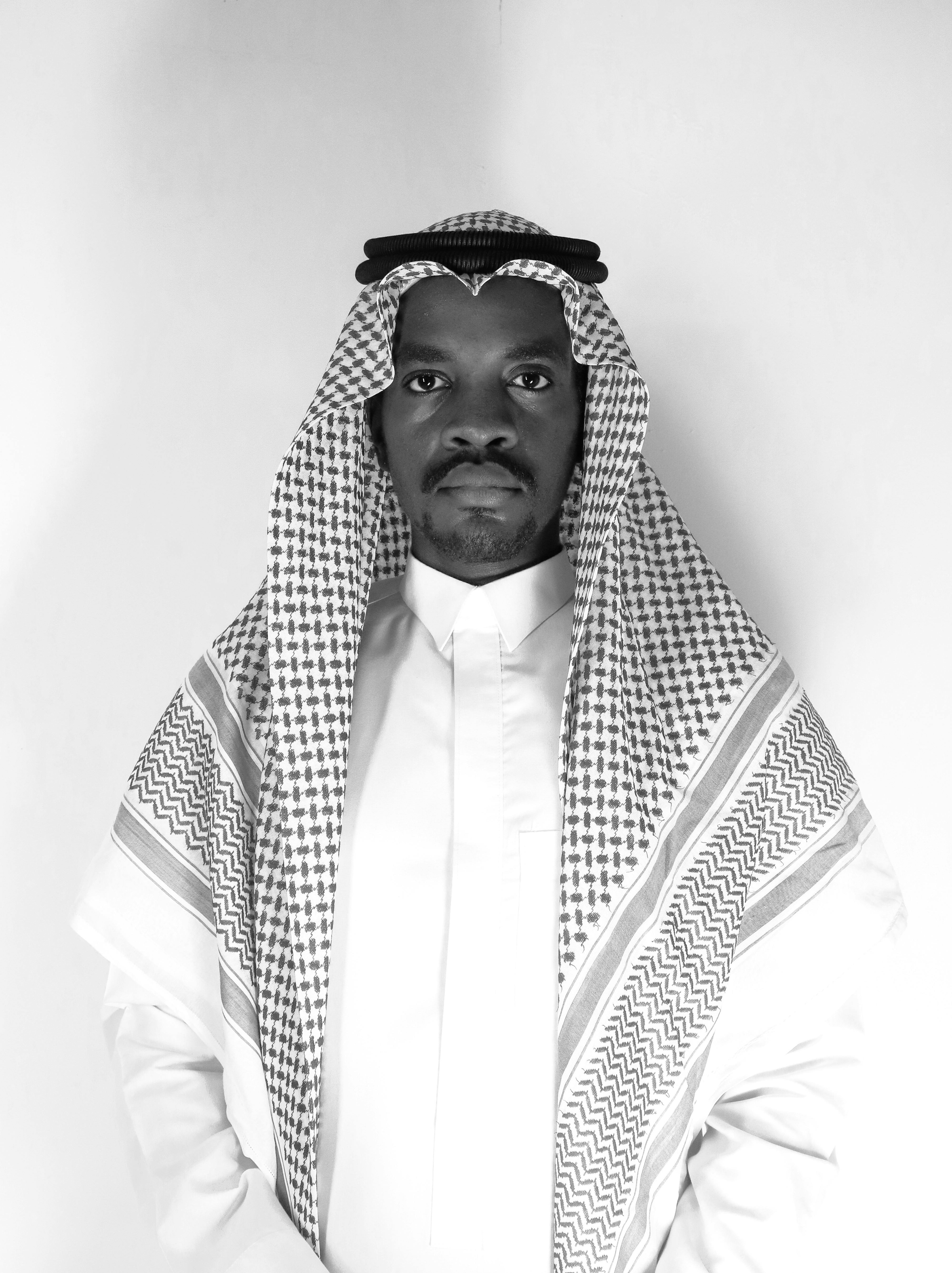 Monochrome portrait of a man wearing traditional Saudi Arabian attire, emphasizing cultural authenticity.