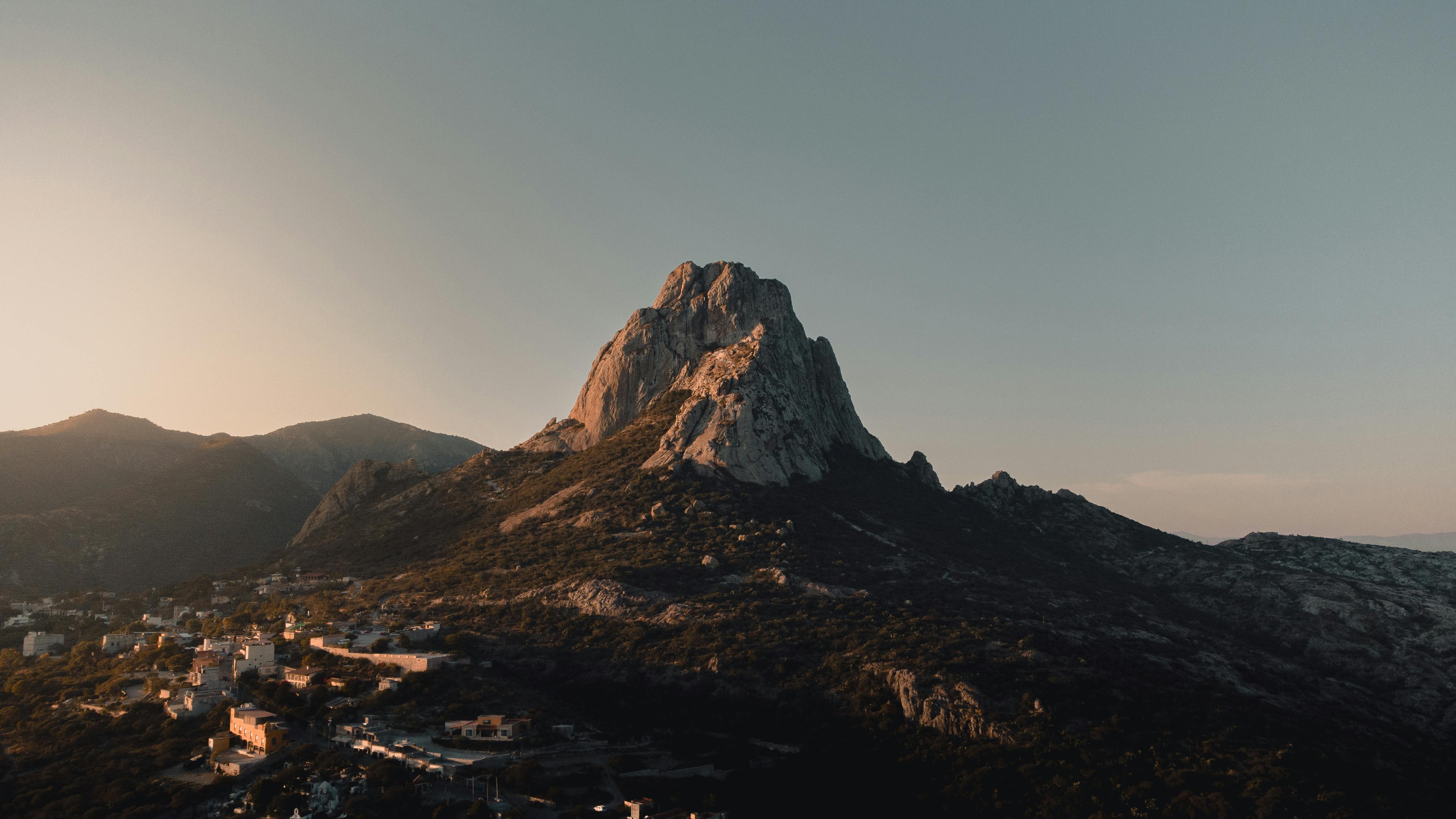 Scenic aerial shot of the Peña de Bernal monolith in Mexico during sunset, showcasing its natural beauty.