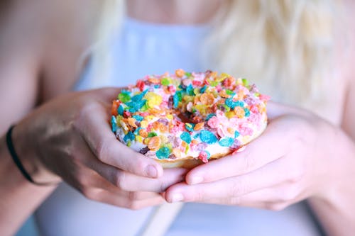 Free Person Holding Doughnut With Toppings Stock Photo