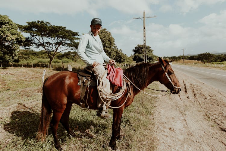 Man With Lasso On Horse Standing By Road