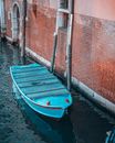 Blue Boat on Water Near Brown Brick Wall
