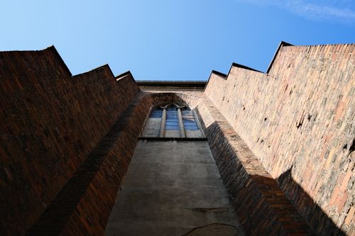 Free Low angle view of historic brick tower against a clear blue sky in Poznań, Poland. Stock Photo