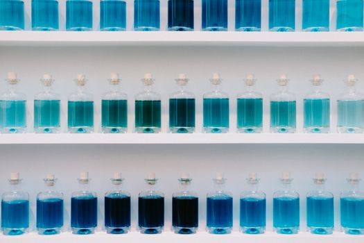 Rows of Carafes with Blue Liquid on Shelves