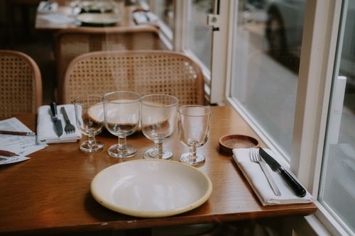 Free Inviting table setting with glasses and cutlery in a cozy restaurant, showcasing warmth and hospitality. Stock Photo