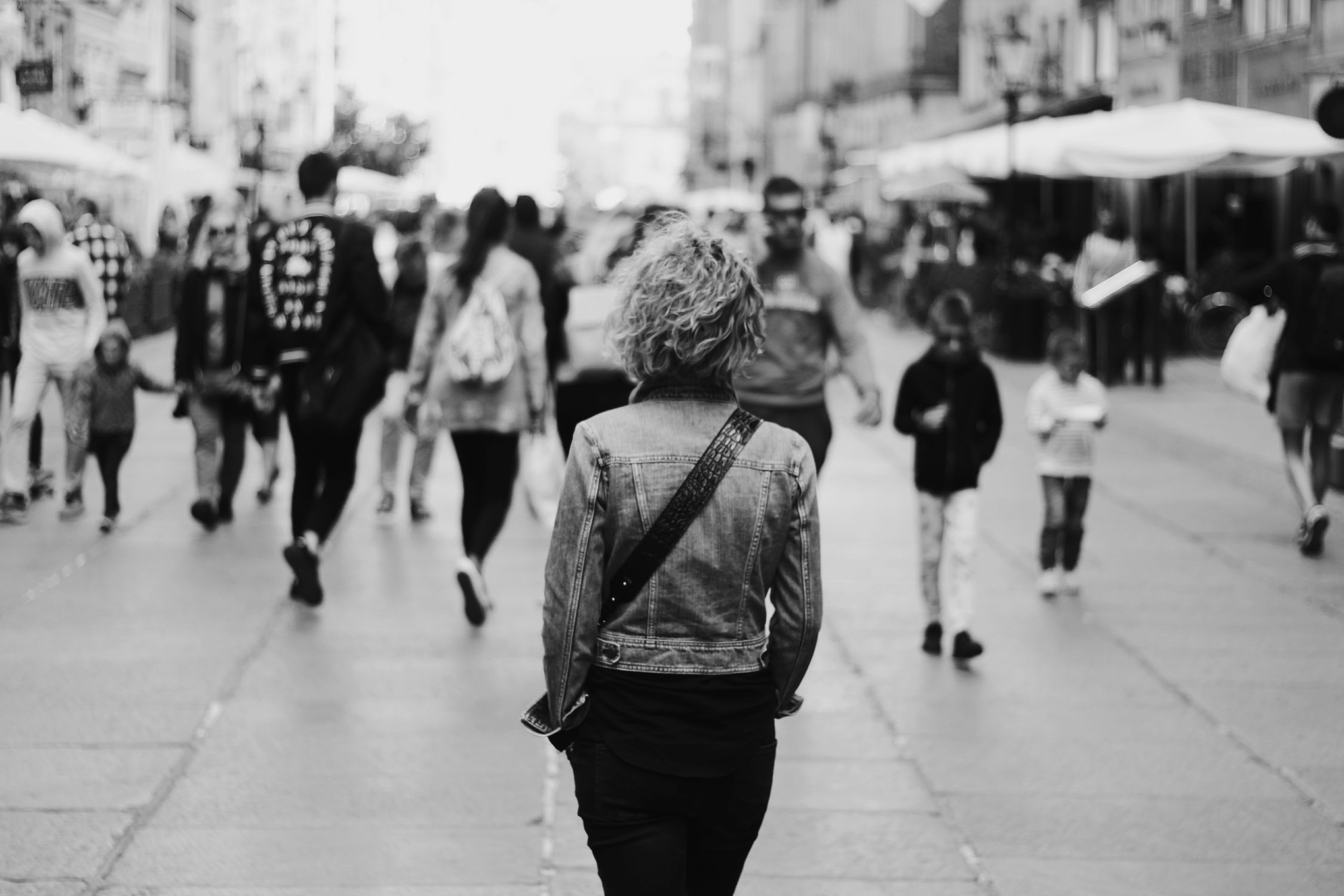 Mulher caminhando sozinha em ambiente urbano, representando o isolamento social e a solidão subjetiva