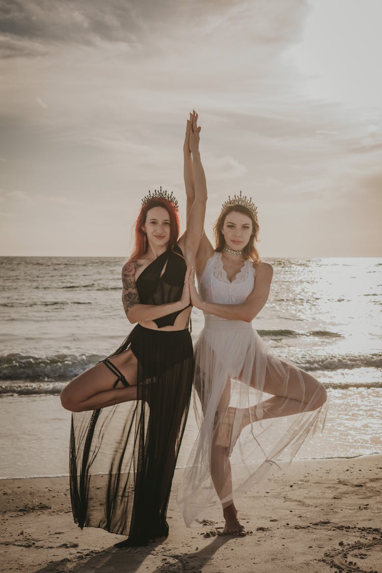 Photo Of Women Standing In Crowns On A Beach