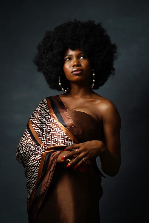 Studio Shot of a Beautiful Woman with Afro Hair Wearing a Brown Dress