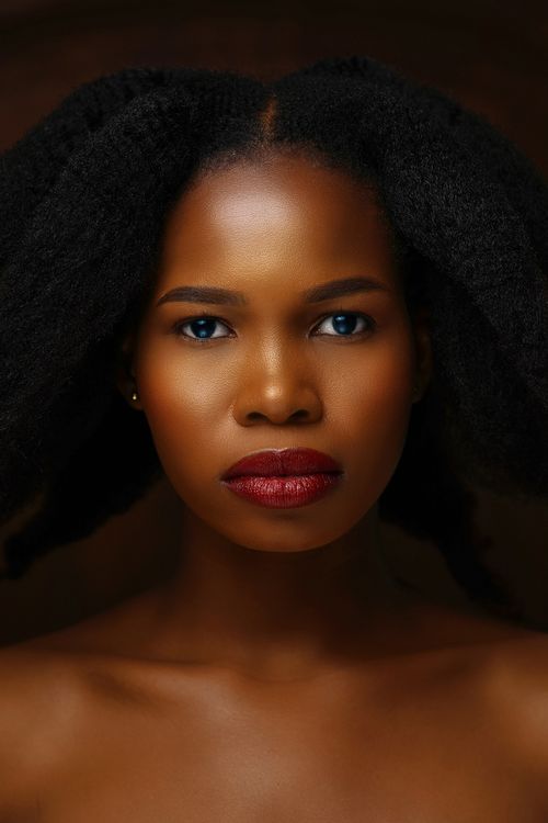 Free Close-up portrait of a beautiful woman with natural afro hair showcasing bold makeup. Stock Photo
